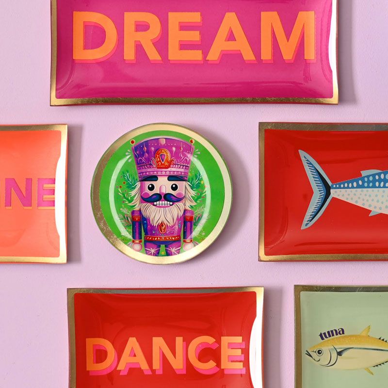Bunte Love Plates von Gift Company mit Pop-Art-Motiven, Fischen und Schriftzügen als kreative Wand- und Tischdekoration.