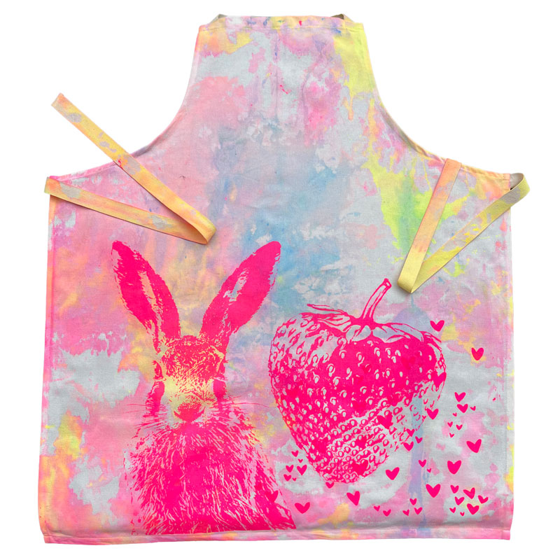 Schürze "Erdbeerhase" Frohstoff Schürze mit pinkfarbenem Hasen- und Erdbeermotiv auf buntem Hintergrund – handbedruckte Leinenschürze im fröhlichen Design für Küche und Garten.