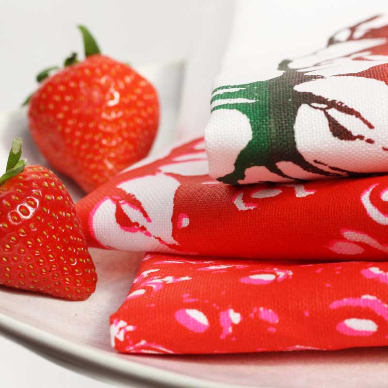 Frohstoff Geschirrtücher mit Erdbeermotiv – handbedruckte Leinentücher in Rot und Pink, inspiriert von Sommerfrüchten, stilvoll dekoriert mit frischen Erdbeeren.