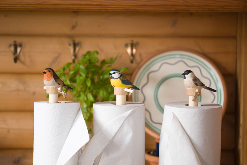Küchenrollenhalter von Wildlife Garden – handgeschnitzte Holzfiguren mit Vögeln wie Rotkehlchen, Blaumeise und Weidenmeise. Natürliche Deko mit praktischem Nutzen für die Küche.