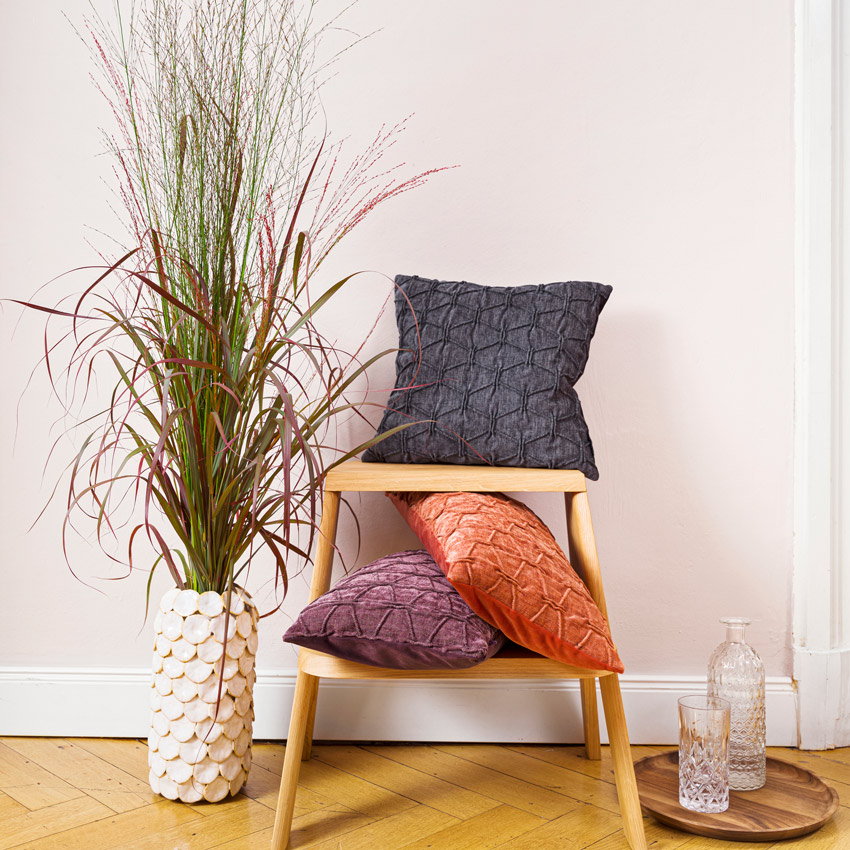 Magma Kissenserie „Matrix“ mit strukturierter Oberfläche in Samtoptik – elegante Kissen in Anthrazit, Orange und Violett, stilvoll arrangiert im modernen Wohnambiente.