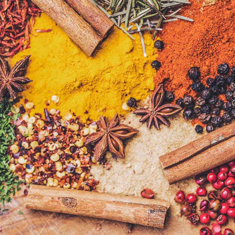 Bunte Gewürze und Kräuter wie Zimt, Sternanis, Kurkuma und Pfeffer – natürliche Inspiration für Schulthess Kerzen mit warmen, würzigen Düften und aromatischer Atmosphäre.