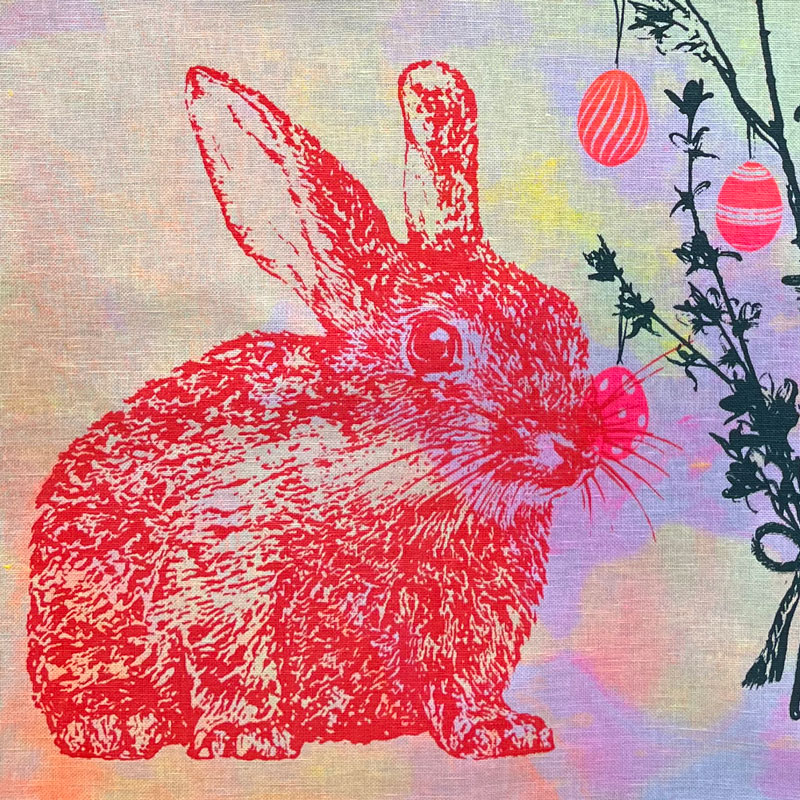 Frohstoff Geschirrtuch mit rotem Osterhasen-Motiv – handbedrucktes Leinentuch mit buntem Batik-Hintergrund und Ostereiern, perfekt als Frühlings- oder Osterdekoration.