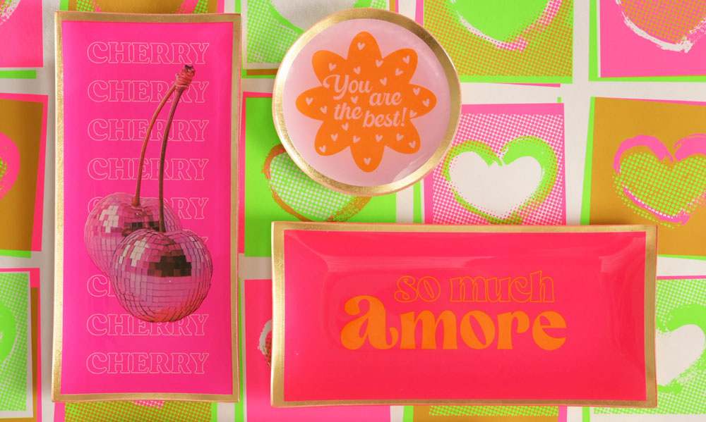 Bunte Glasteller von Gift Company im Pop-Art-Stil mit Aufschriften „Cherry“, „You are the best!“ und „So much Amore“. In kräftigen Pink-, Orange- und Grüntönen mit glänzenden Akzenten gestaltet.