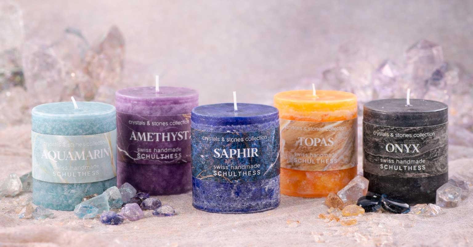 Schulthess Duftkerzen Crystals & Stones Kollektion mit Aquamarin, Amethyst, Saphir, Topas und Onyx – farbintensive Edelstein-Kerzen stilvoll arrangiert mit Kristallen
